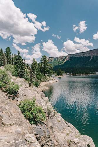 electra lake green trees and mountain by the water under blue sky and white clouds during daytime landscape